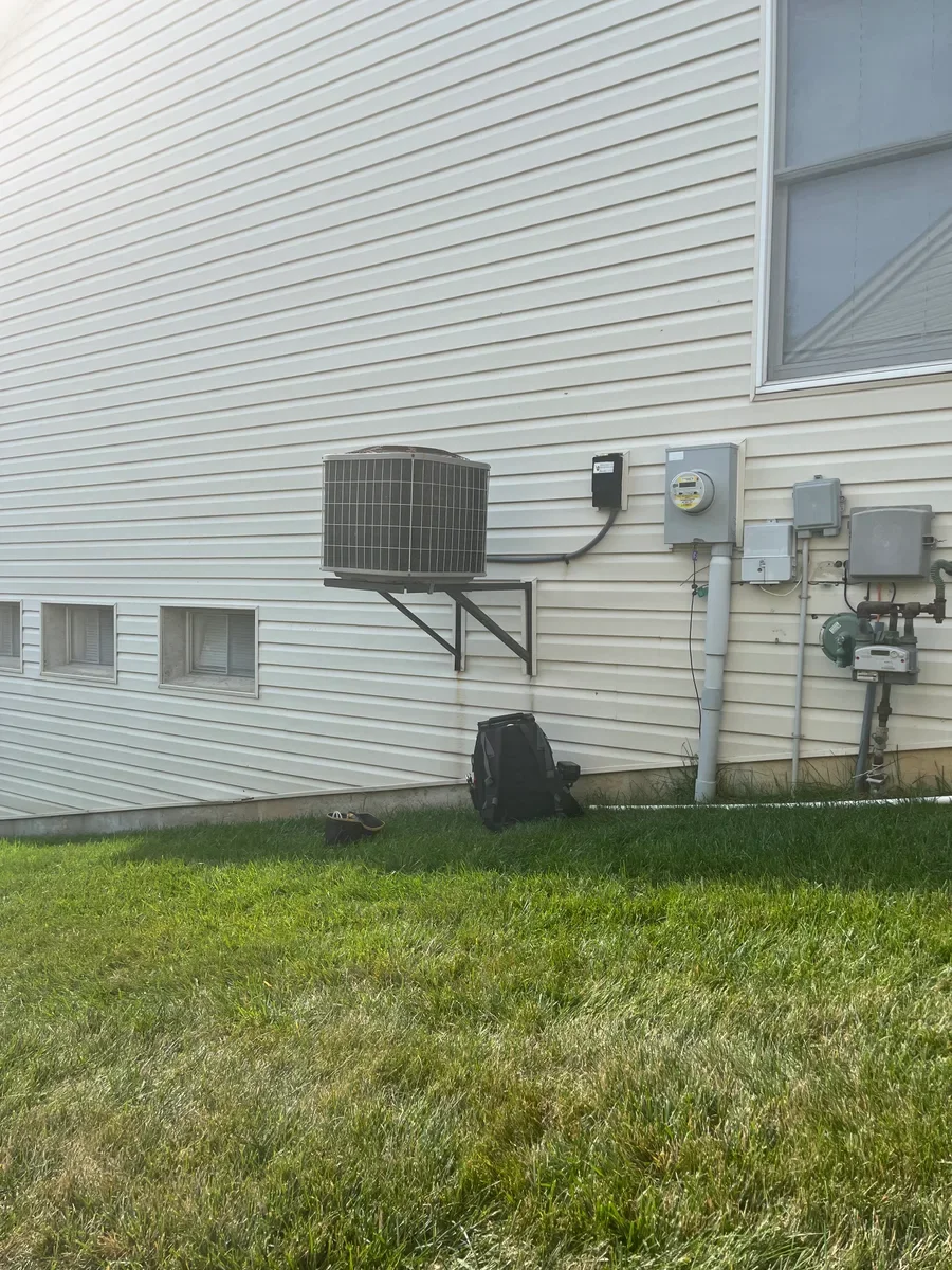 Original wall-mounted air conditioner with the nearby meters before replacement in O'Fallon.