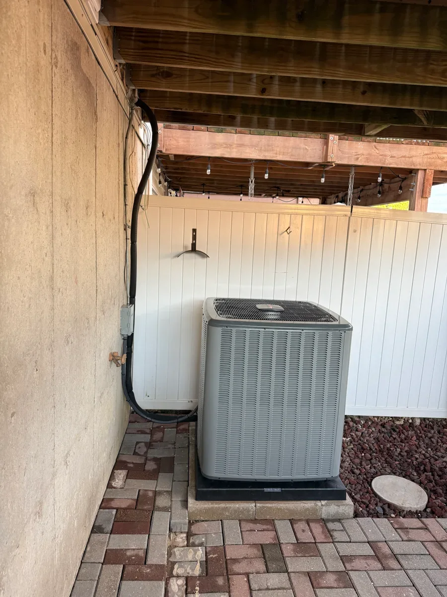 Completed air conditioner replacement beside the same covered brick patio in O'Fallon.