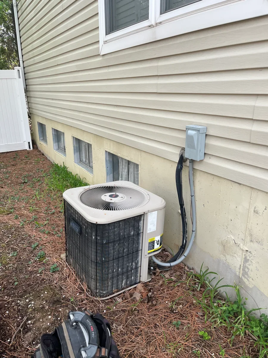 Original outdoor air conditioner before replacement beside a St. Charles home.