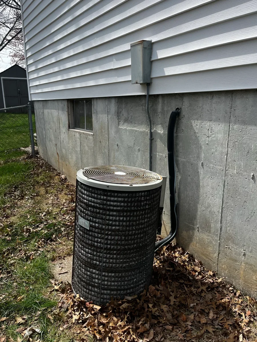 Original air conditioner beside the foundation and electrical disconnect before replacement in St. Peters.
